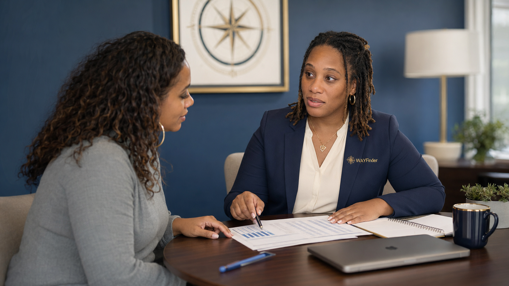 Nichole Braxton reviews student data one-on-one with an educator across a small office table.
